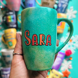 A hand-painted green galaxy mug with the name 