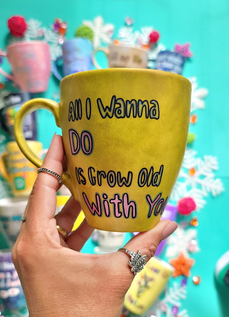 A hand-painted greenish bronze mug with words