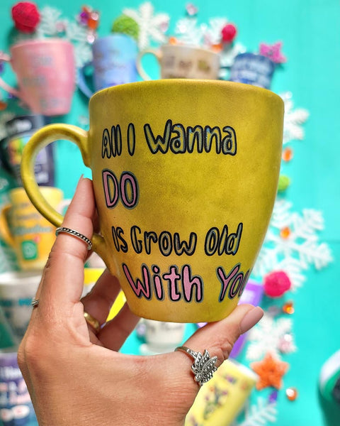 A hand-painted greenish bronze mug with words