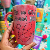 A hand-painted red galaxy mug with the words 