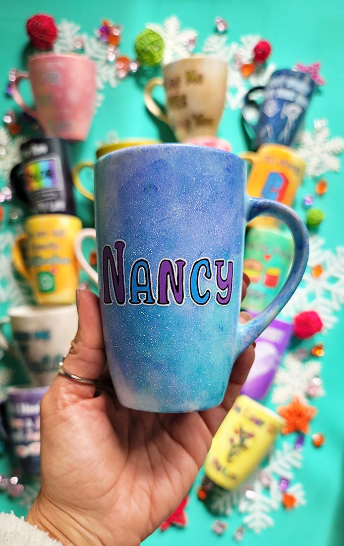 A hand-painted  light blue purple mug with the name "Nancy"