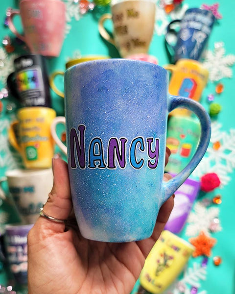 A hand-painted  light blue purple mug with the name "Nancy"