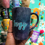 A hand painted black galaxy mug with the name 