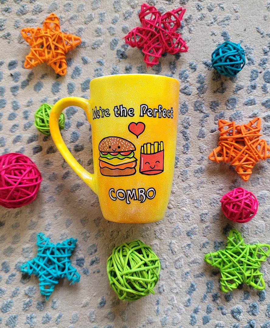 A hand-painted yellow orange mug with the words "we're the perfect combo"