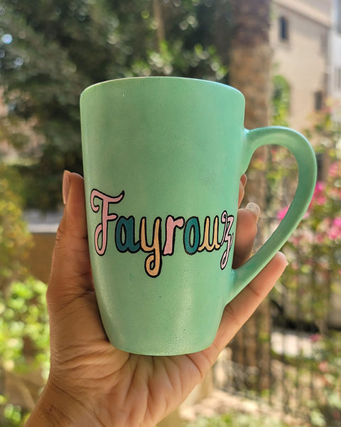 A Hand painted green Mug with the name "Fayrouz" written