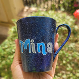 a Bluish galaxy hand painted mug with the name 