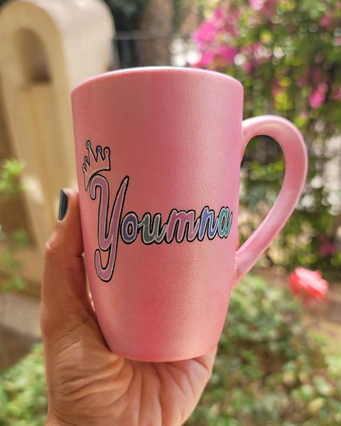 A shimmery pink hand-painted mug with the word miss crossed out and the name "Youmna" and a little crown on the letter Y