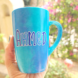 A blue hand painted mug with the name 