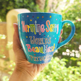 A blue hand painted mug with the words 