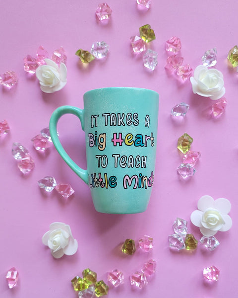 A Mint green handpainted mug with the words "its takes a big heart to teach little minds"