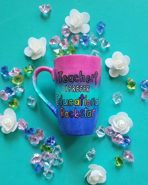 A Gradient hand painted mug (Pink Green and ultramarine) with the sentence "Teacher? I prefer Educational Rockstar"