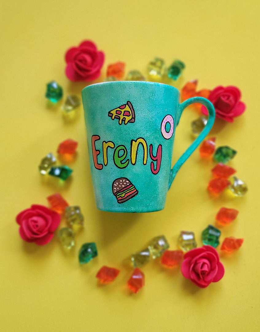 A green Galaxy hand painted mug with the name "Ereny" and fast food items scattered all over