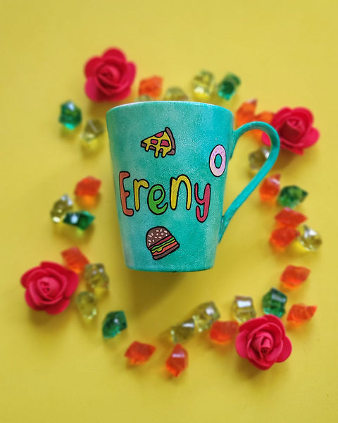 A green Galaxy hand painted mug with the name "Ereny" and fast food items scattered all over