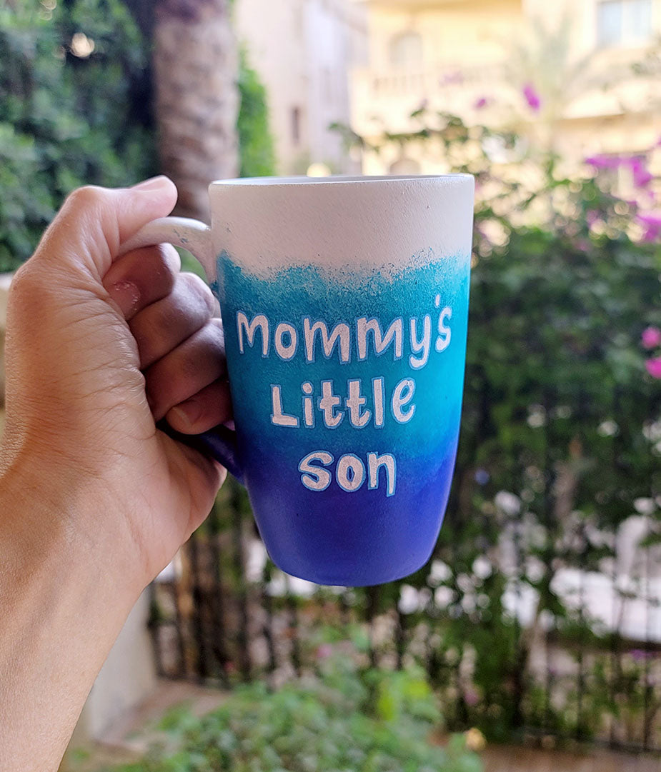 A Gradient hand painted mug with the colors (White turquoise and ultramarine) with the words "mommy's little son"