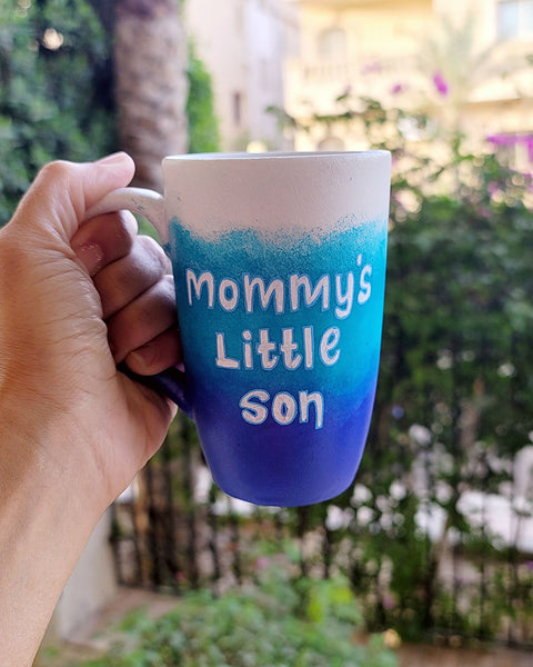 A Gradient hand painted mug with the colors (White turquoise and ultramarine) with the words "mommy's little son"