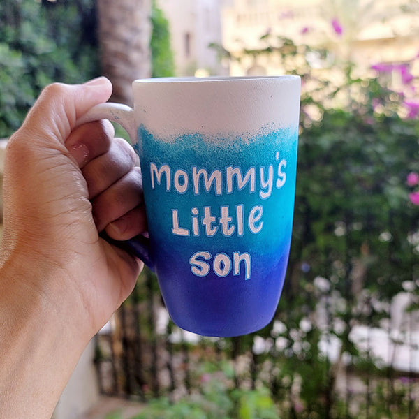 A Gradient hand painted mug with the colors (White turquoise and ultramarine) with the words "mommy's little son"