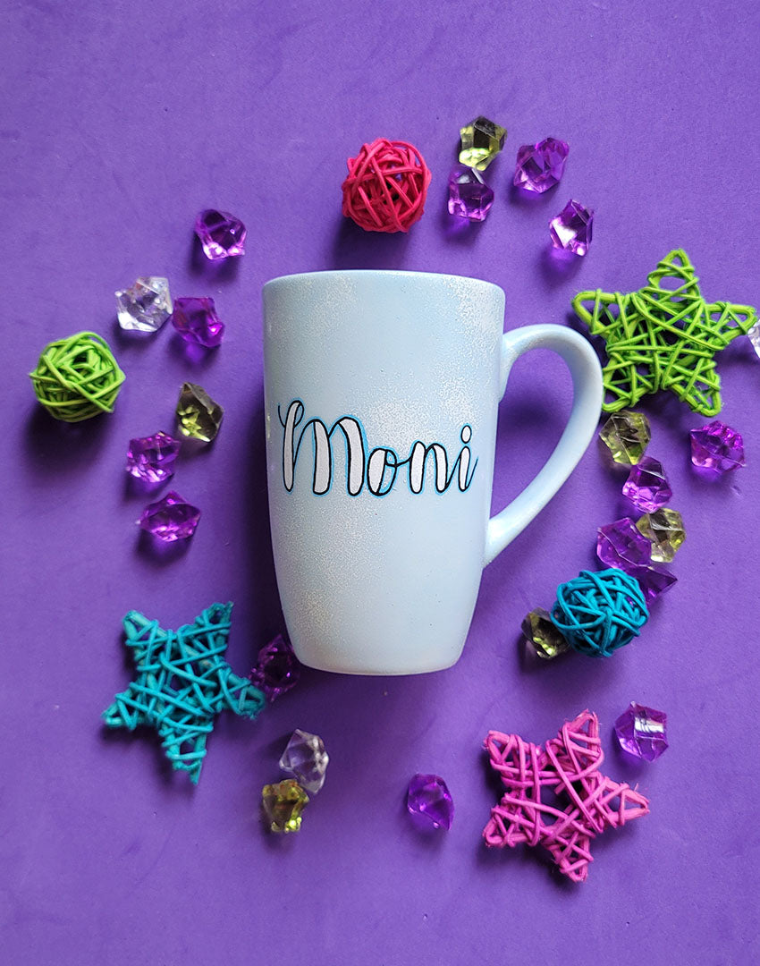 A baby blue hand painted mug with the name "Moni"