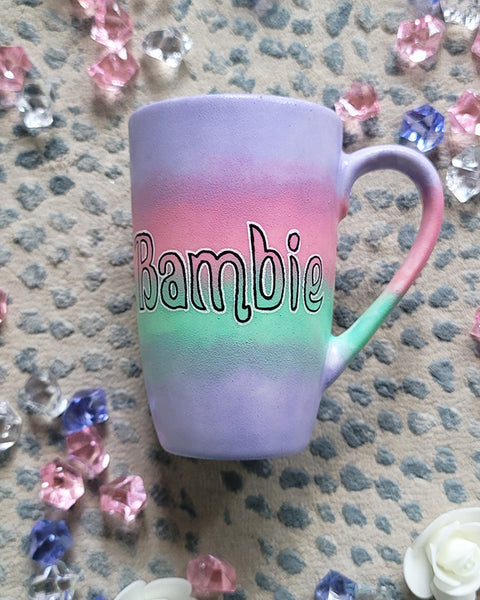 A gradient hand painted mug (lilac-pink-mint-lilac) with the word Bambie written