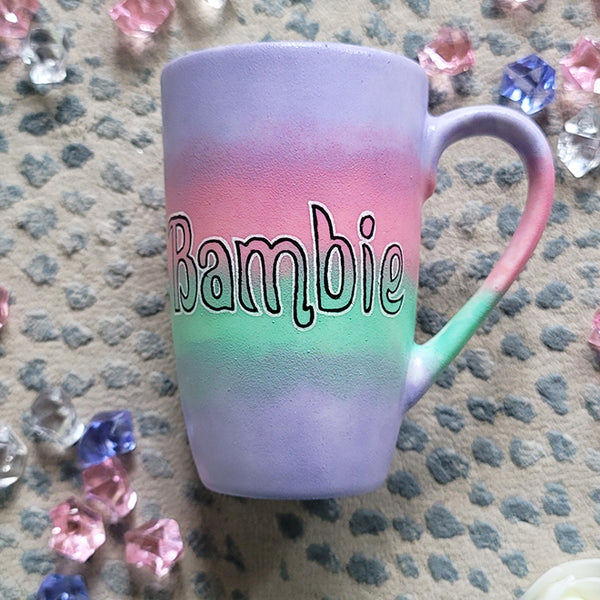 A gradient hand painted mug (lilac-pink-mint-lilac) with the word Bambie written