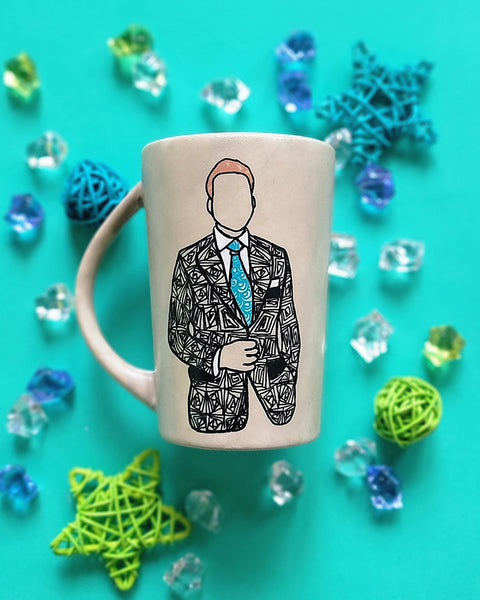 A taupe hand painted mug with a silhouette of a man in a suit filled with patterns