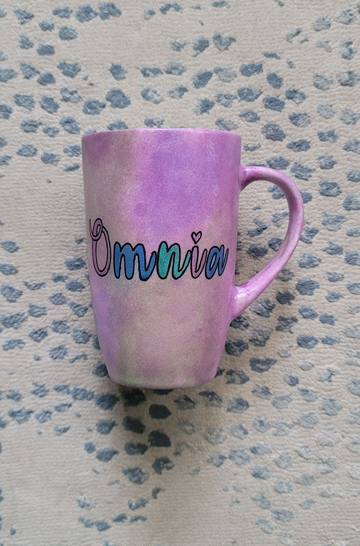 A Pastel Pink hand painted mug with the name "Omnia"