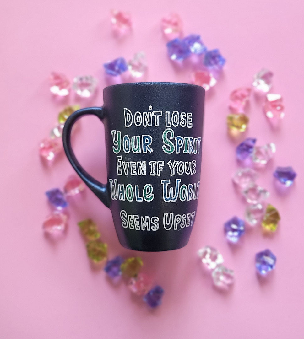 A Shimmery blue hand painted mug with the words "Don't lose your spirit, even if the whole world seems upset"