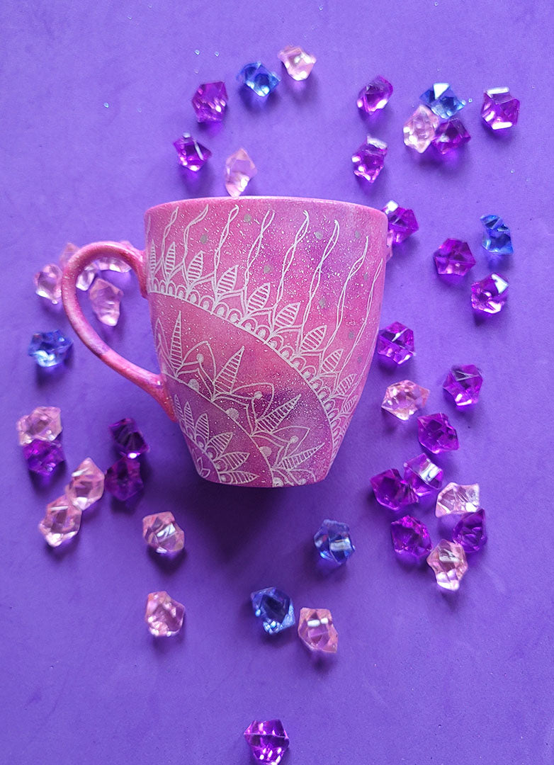 A Pink galaxy Hand painted mug with a 1/4 mandala drawn starting at the corner