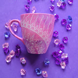 A Pink galaxy Hand painted mug with a 1/4 mandala drawn starting at the corner