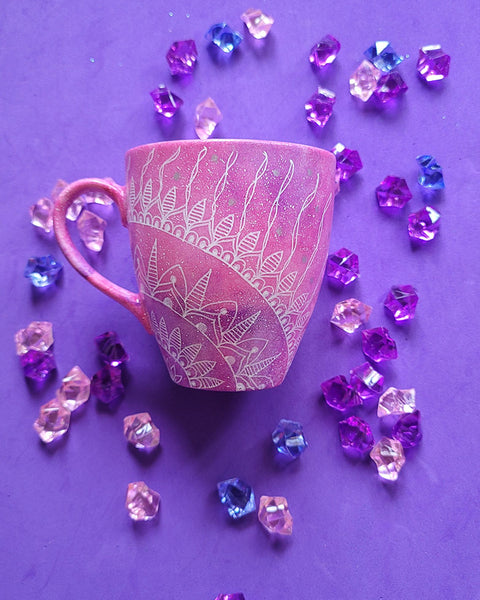 A Pink galaxy Hand painted mug with a 1/4 mandala drawn starting at the corner