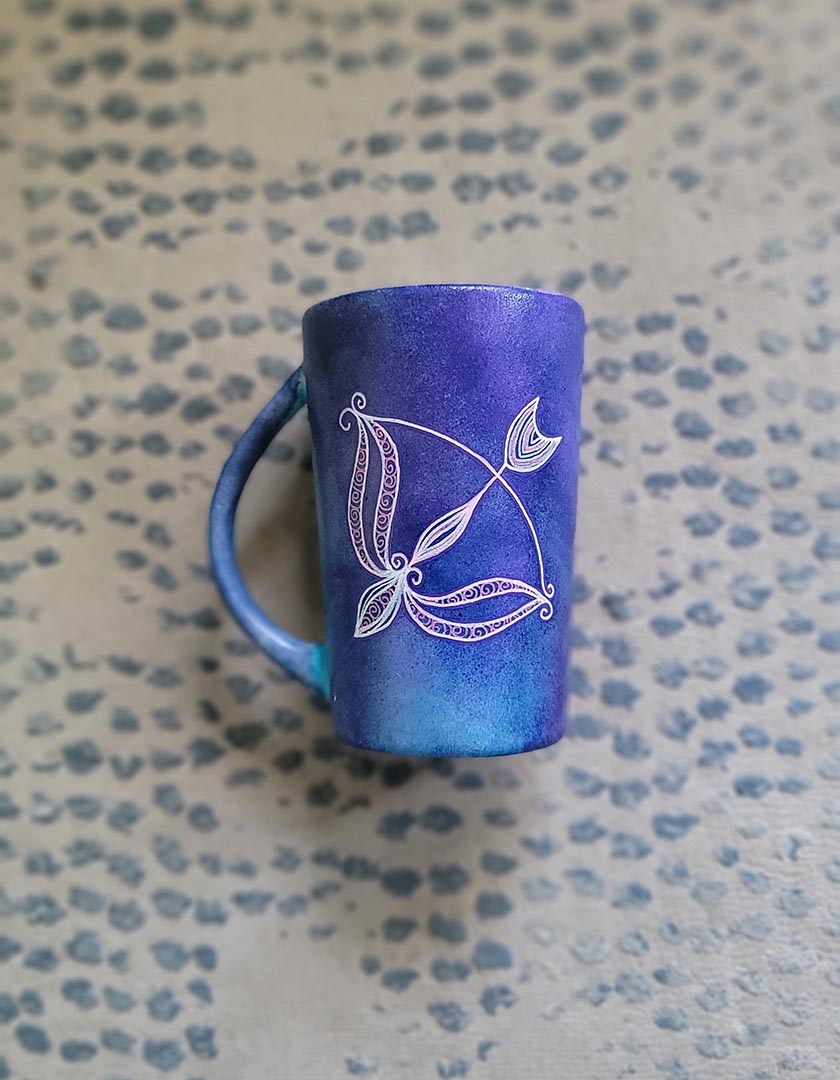 a hand-painted dark blue sky mug with a Sagittarius sign