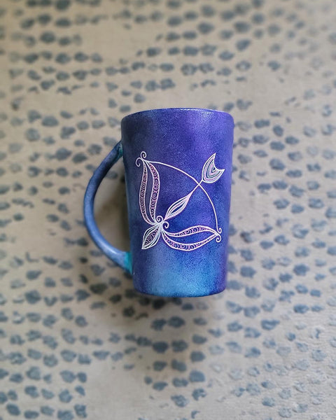 a hand-painted dark blue sky mug with a Sagittarius sign