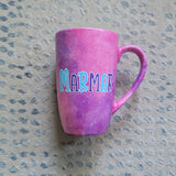 A hand painted pink galaxy mug with the name 