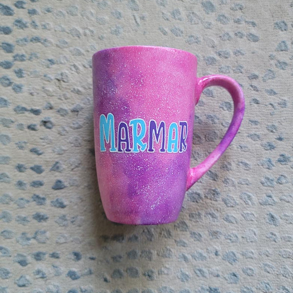 A hand painted pink galaxy mug with the name "marmar"