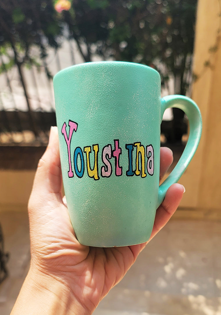 a min green hand painted mug with the name "youstina"