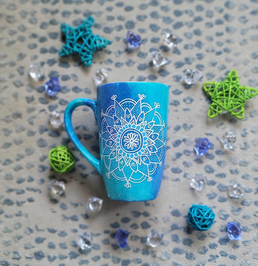 A Blue Galaxy Hand Painted mug with a mandala painted in white