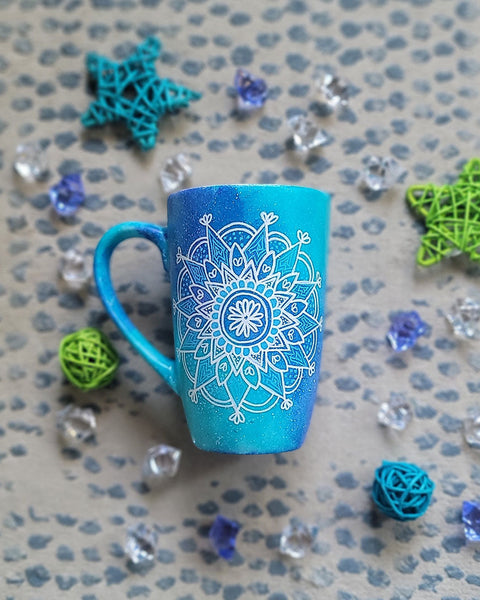 A Blue Galaxy Hand Painted mug with a mandala painted in white