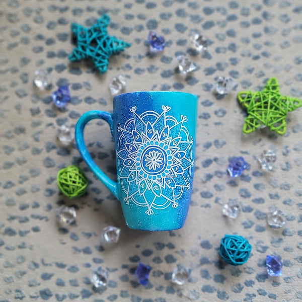 A Blue Galaxy Hand Painted mug with a mandala painted in white