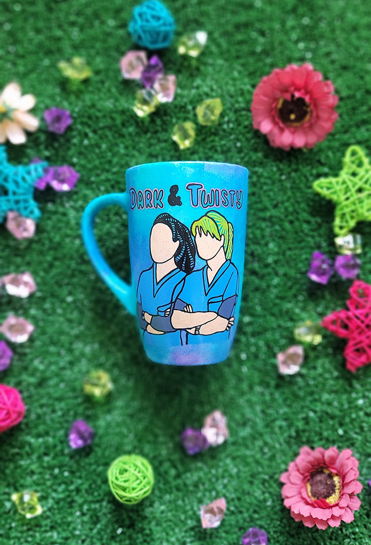 A Blue Hand painted mug with the words "dark and twisty" written on top and a silhouette of 2 girls in medical coats