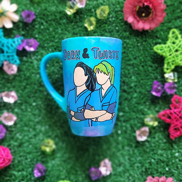 A Blue Hand painted mug with the words "dark and twisty" written on top and a silhouette of 2 girls in medical coats