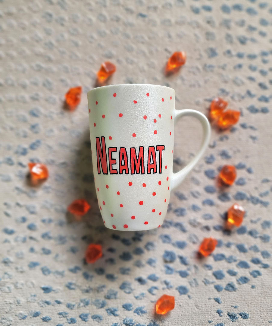 A Pearl White hand painted mug with the name "neamat" with red dots scattered all over