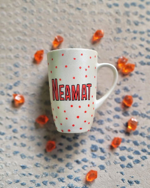 A Pearl White hand painted mug with the name "neamat" with red dots scattered all over