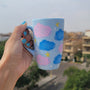 A Baby Blue Hand painted mug with colorful clouds (pink and blue) drawn all over with yellow stars