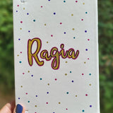 A Pearl white notebook with the name 