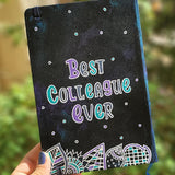 A black galaxy hand painted notebook with doodles at the bottom and the words 