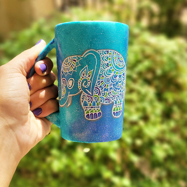 A Blue Galaxy hand painted mug with an elephant zentangle design on it in white