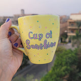 A Pastel yellow hand painted mug with the words 