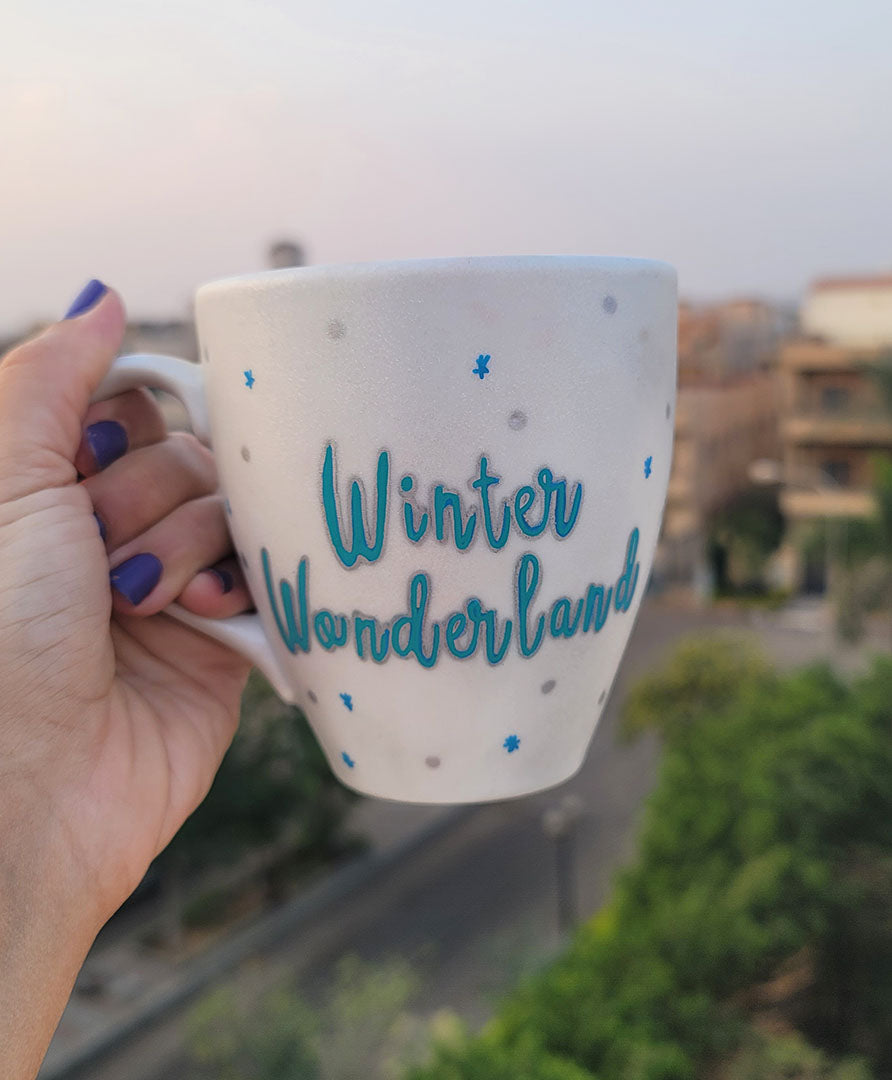 A Pearl White Hand painted mug with the words "Winter Wonderland" on turquoise