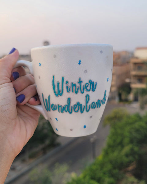 A Pearl White Hand painted mug with the words "Winter Wonderland" on turquoise