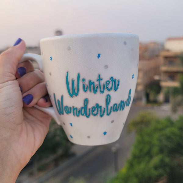 A Pearl White Hand painted mug with the words "Winter Wonderland" on turquoise