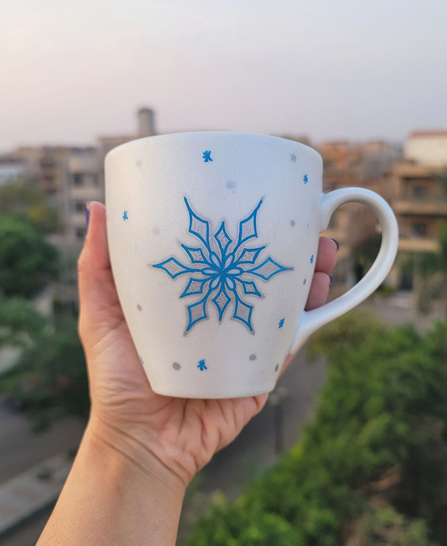 A Pearl White Hand painted mug with a snowflake inurquoise